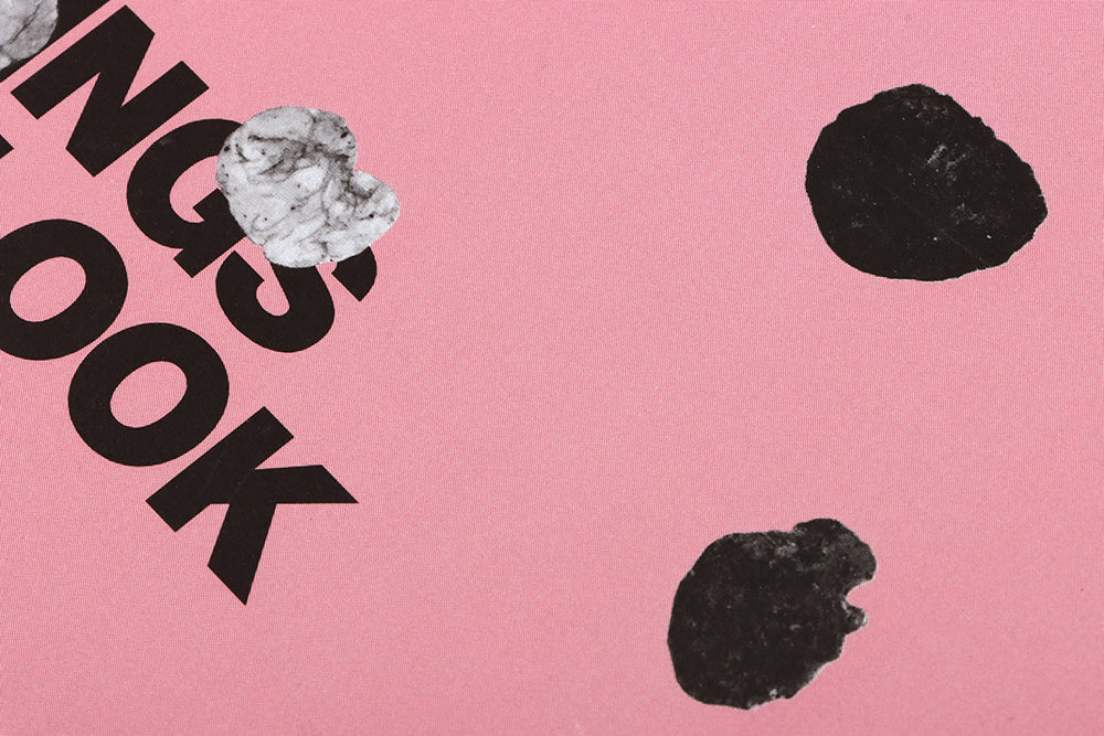 Pink magazine cover with partially visible black text reading "NGS OOK" and black marks